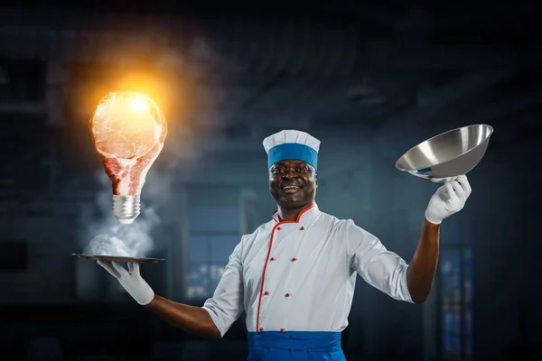 Siyah adam önlük giyiyor ve yemek pişiriyor. Karışık ortam — Stok fotoğraf