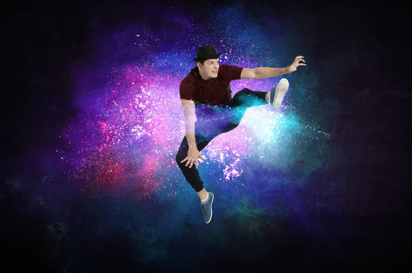 Modern dancer jumping with colourful splashes background. Mixed media — Stock Photo, Image