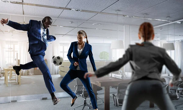 Black businessman playing footbal in office — Stock Photo, Image