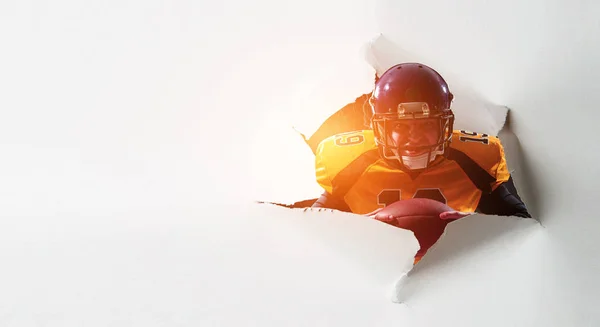 Paper breakthrough hole effect and football player. Mixed media — Stock Photo, Image