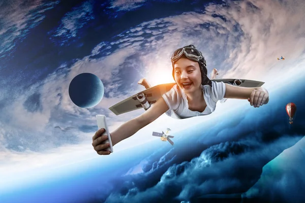 Mädchen fliegen mit selbstgebastelten Flugzeugflügeln. Gemischte Medien — Stockfoto