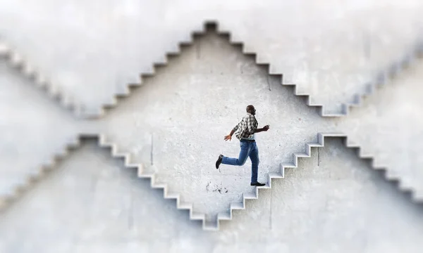 Uomo d'affari nero salire scale di pietra che illustrano lo sviluppo della carriera e il concetto di successo. Mezzi misti — Foto Stock