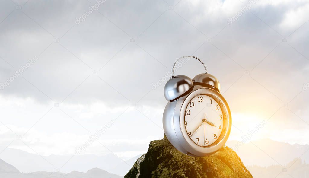 Clock on the ground with mountain landscape view
