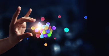 Yukarıda havada duran bir grup küreyi tutan kadın eli. Karışık ortam