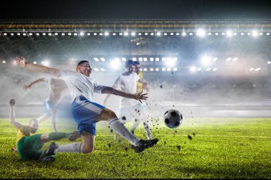 Stadyumdaki futbol oyuncuları iş başında. Karışık ortam