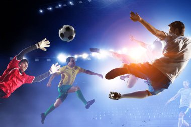 Stadyumdaki futbol oyuncuları iş başında. Karışık ortam