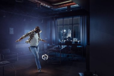 Siyah bir erkek futbol oynarken sanal gerçeklik kulaklığı. Karışık ortam