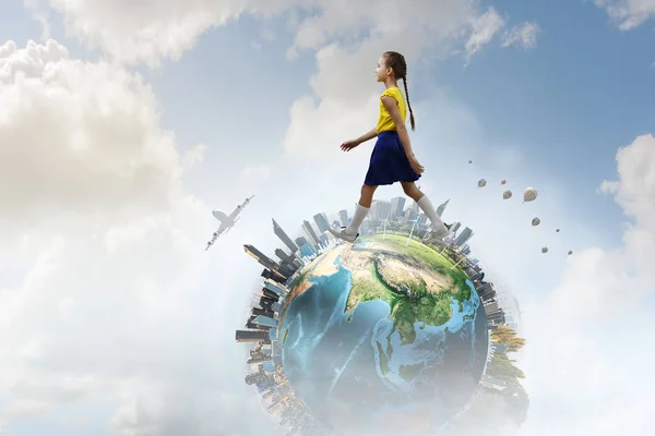 Cute joyful little girl walking on the globe. Mixed media — Stock Photo, Image