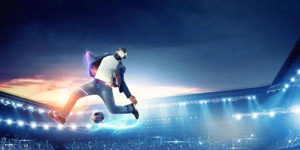 Zestaw słuchawkowy Virtual Reality na czarnym mężczyźnie grającym w piłkę nożną. Media mieszane — Zdjęcie stockowe