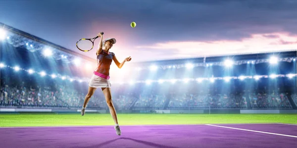 Mujer joven jugando al tenis en acción — Foto de Stock