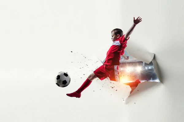 Χαρτί σχισμένο αποτέλεσμα τρύπας και ένα παιδί που παίζει ποδόσφαιρο. Μεικτά μέσα — Φωτογραφία Αρχείου
