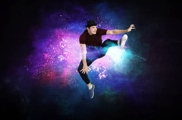 Modern dancer jumping with colourful splashes background. Mixed media — Stock Photo, Image