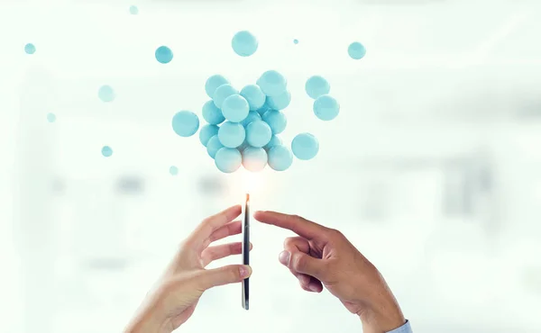 Businessman hands holding a smartphone with a bunch of spheres levitating above. Mixed media — Stock Photo, Image