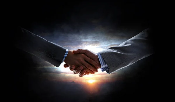 Business handshake by a man and a woman. Mixed media — Stock Photo, Image