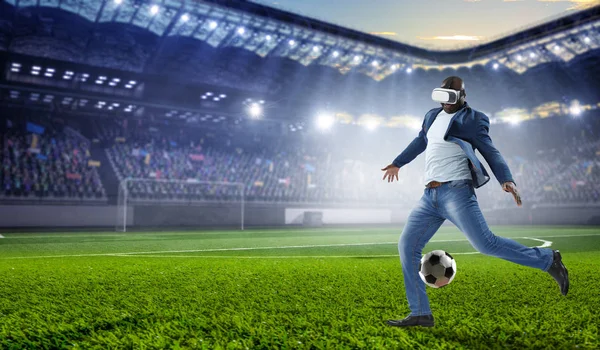 Auriculares de realidad virtual en un hombre negro jugando fútbol. Medios mixtos —  Fotos de Stock