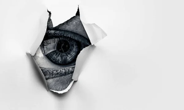 Eye in a hole of torn paper — Stock Photo, Image