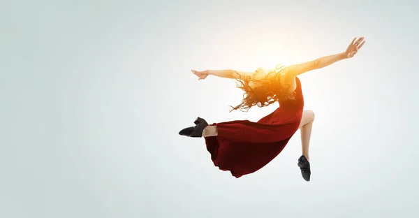 Young and beautiful female dancer in a red dress. Mixed media — Stock Photo, Image