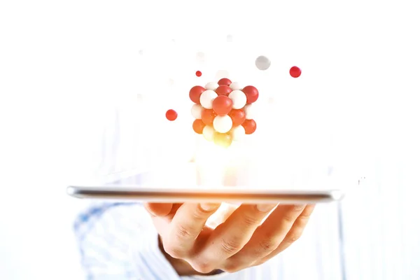 Businessman hand holding a smartphone with a bunch of spheres levitating above. Mixed media — Stock Photo, Image