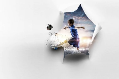 Kağıt yırtık delik etkisi ve bir çocuk futbol oynuyor. Karışık medya