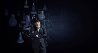 Genç işadamı sınıfta durup düşünüyor. Karışık ortam