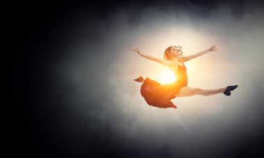 Kırmızı elbiseli genç ve güzel bir bayan dansçı. Karışık ortam