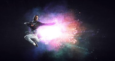 Renkli sıçramaları arka plan ile hoodie atlama modern kadın dansçı. Karışık medya