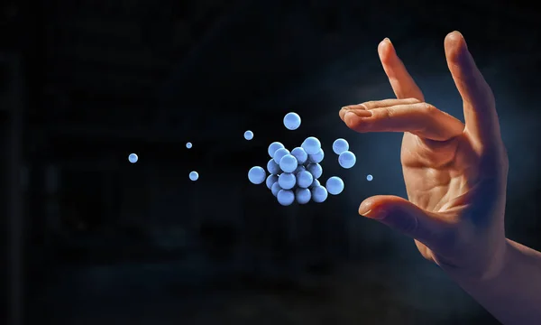 Woman hand and a bunch of spheres levitating beside. Mixed media — Stock Photo, Image