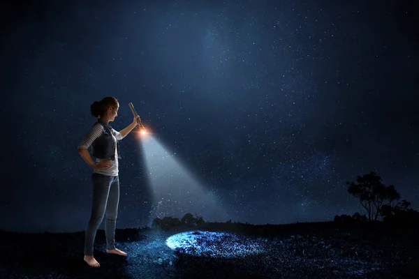 Young woman holding a flashlight — Stock Photo, Image