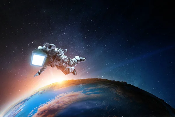 Astronaut met tv-hoofd in de ruimte. Gemengde media. — Stockfoto