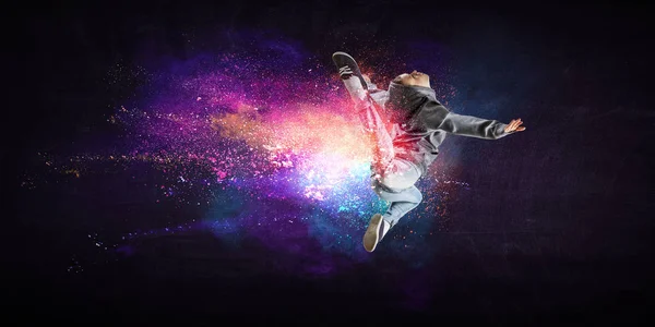 Moderne Tänzerin springt in Kapuzenpulli mit bunten Spritzern Hintergrund. Gemischte Medien — Stockfoto