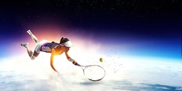 Молодая женщина играет в теннис в действии — стоковое фото