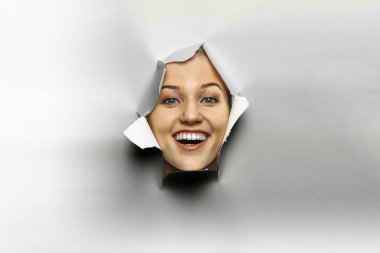 Yırtık bir kağıt deliğinden dışarı bakan kadın