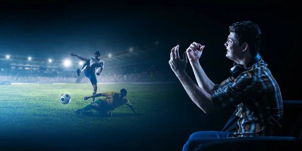 Young man watching football on big screen — Stock Photo, Image