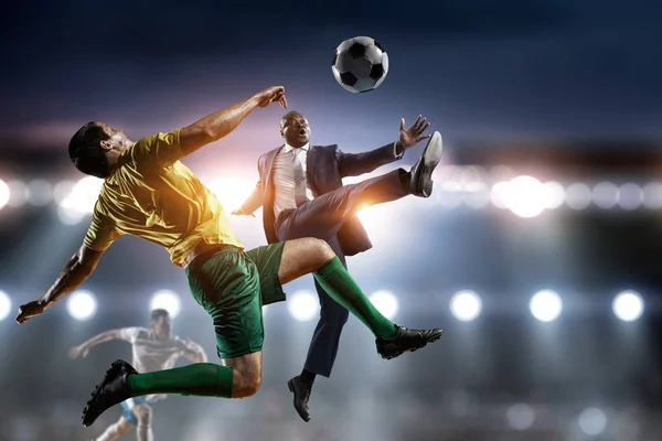 Black businessman playing footbal on a satdium — Stock Photo, Image