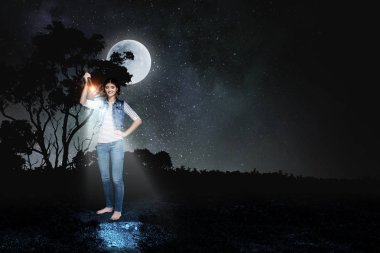 Elinde fener tutan genç bir kadın.