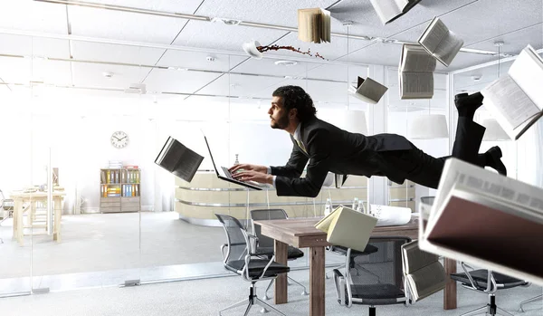 Man flyger och arbetar på laptop. Blandade medier — Stockfoto