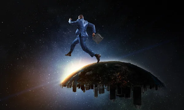 Вид черного бизнесмена, прыгающего и бегущего с городской планеты Земля в звездное пространство — стоковое фото
