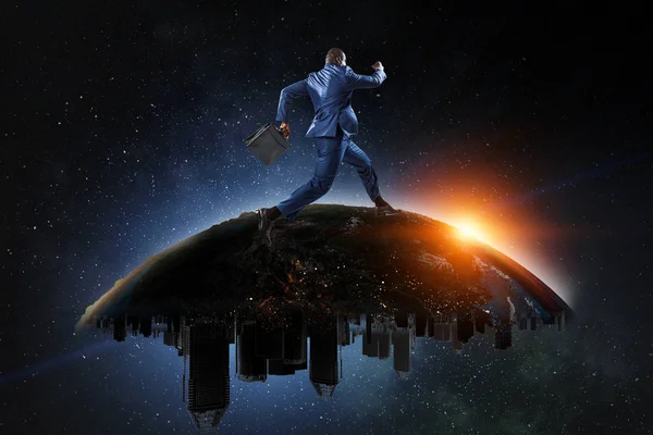 Back view of a black businessman running on the Globe with city scyscrapers on the starry space background — Stock Photo, Image