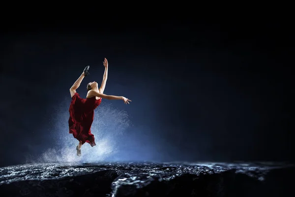 Joven y hermosa bailarina en un vestido rojo saltando —  Fotos de Stock