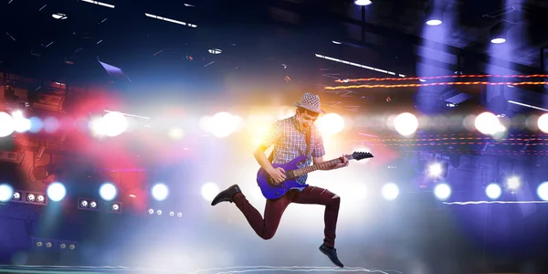 Guitar player jumping with guitar while playing — Stock Photo, Image