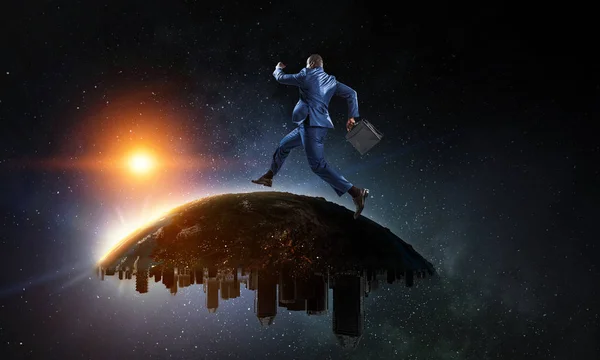 Back view of a black businessman running on the Globe with city scyscrapers on the starry space background — Stock Photo, Image