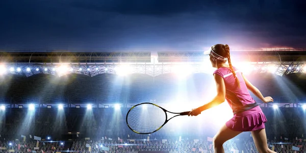 Mujer joven jugando al tenis en acción — Foto de Stock
