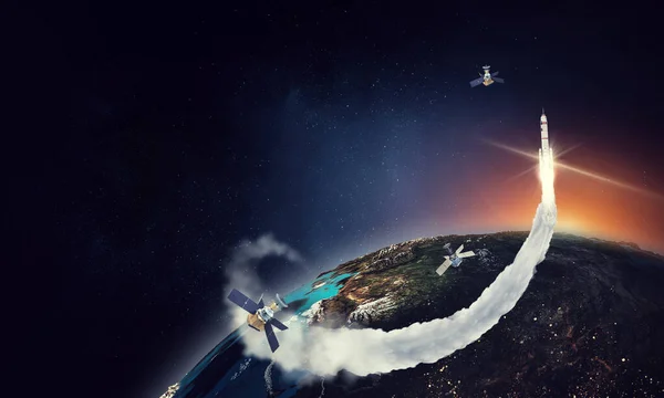 Erath superficie superior con satélites voladores y un cohete — Foto de Stock