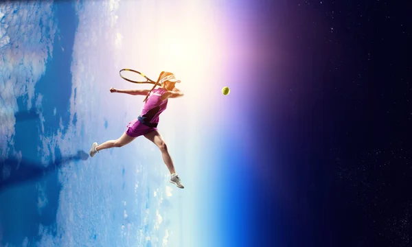 Молодая женщина играет в теннис в действии — стоковое фото