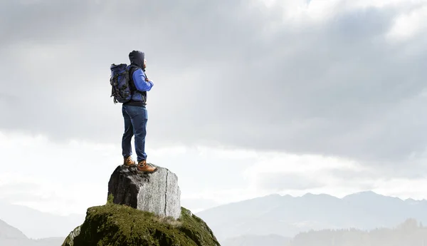 Hiker mannen i bergen. Mixed media — Stockfoto