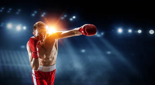 Boxeador profesional golpea en arena oscura — Foto de Stock