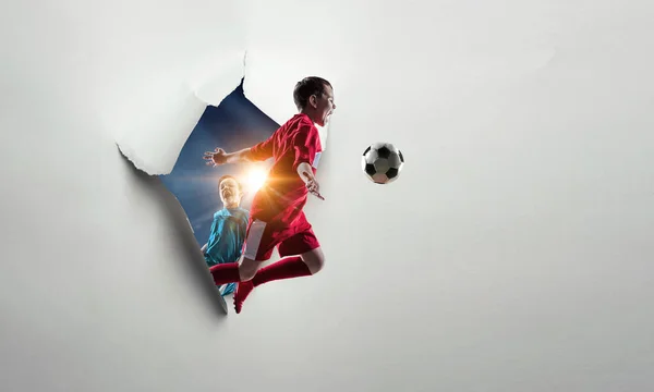 El futbolista chico rompiendo el papel blanco. Medios mixtos — Foto de Stock