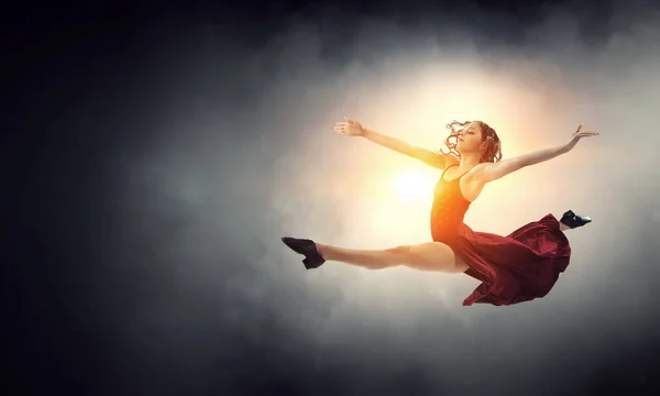 Young and beautiful female dancer in a red dress — Stock Photo, Image