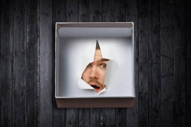 Erkek yüzü kağıttaki delikten geçiyor