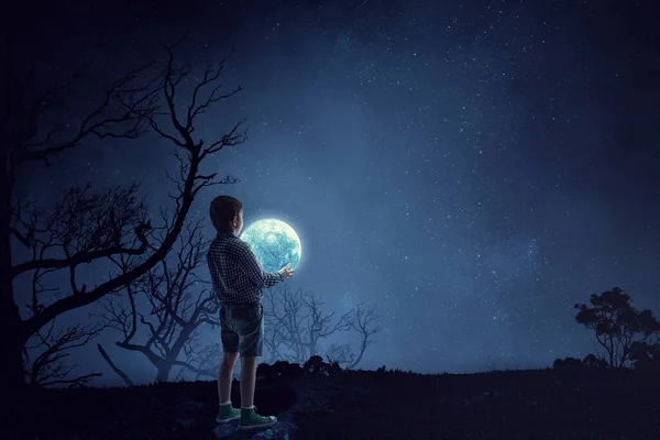 晚上抱着月亮的男孩 — 图库照片
